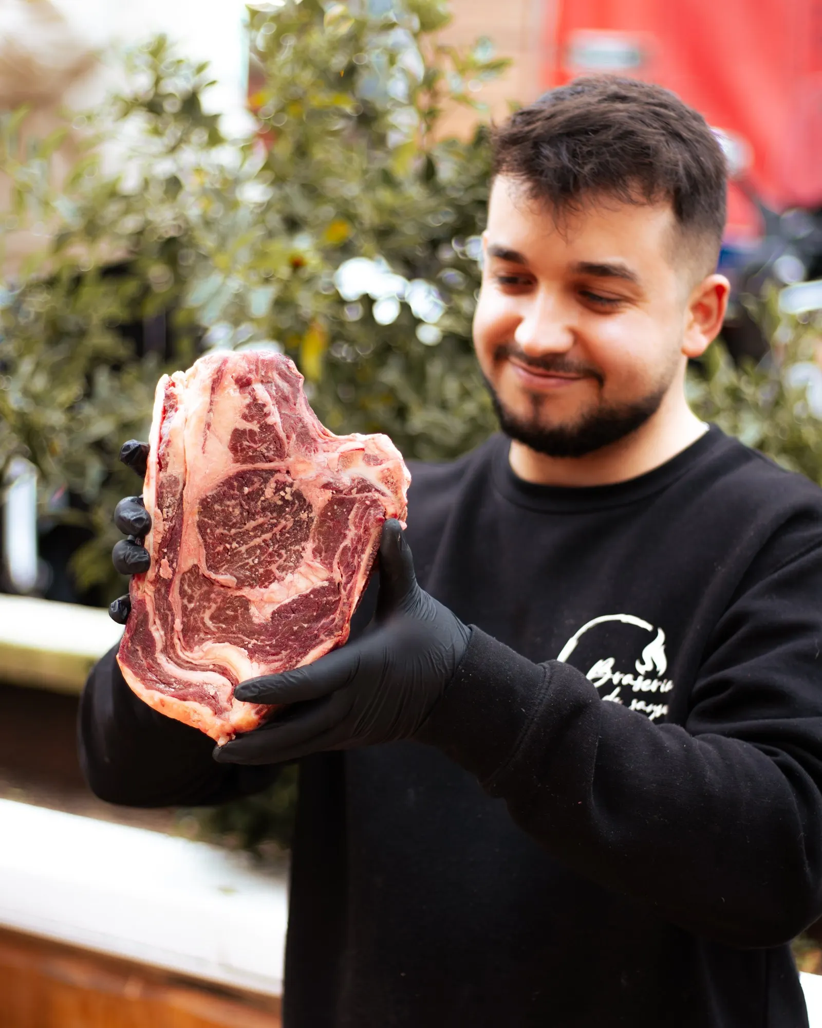 Samu, de La Brasería de Samu, mostrando una pieza de carne madurada